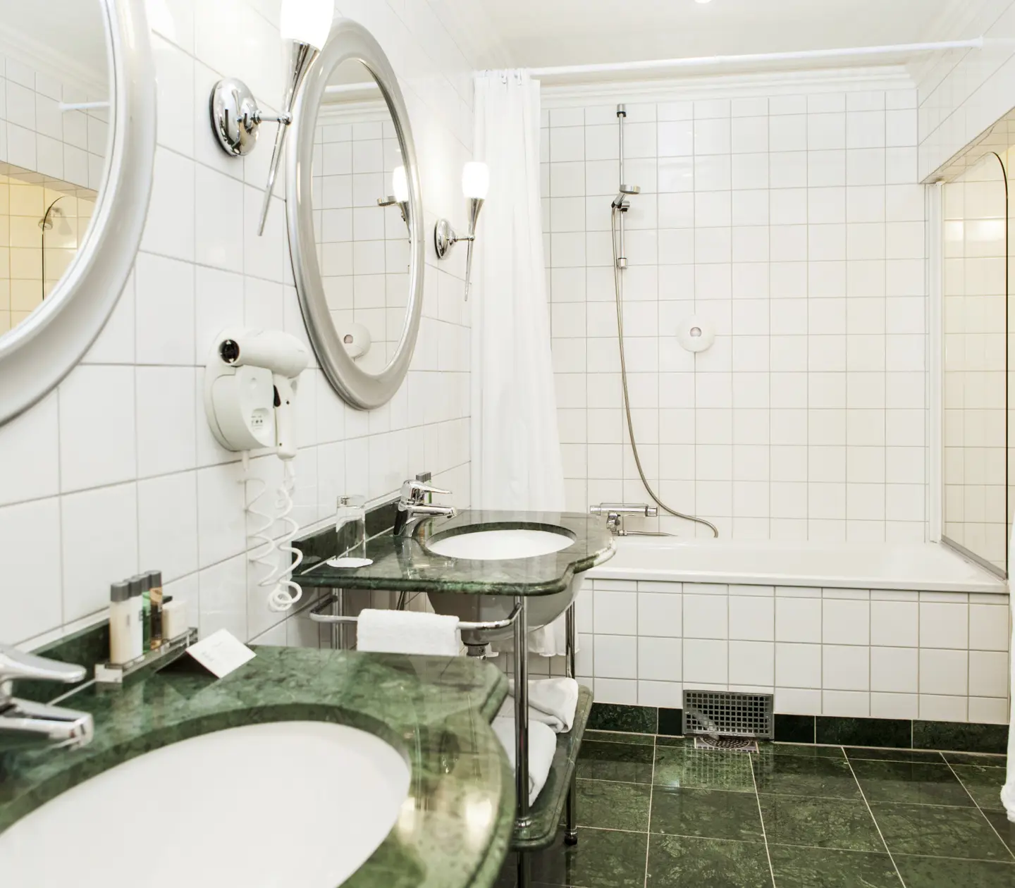 Bathroom with two sinks, bathtub and mirror