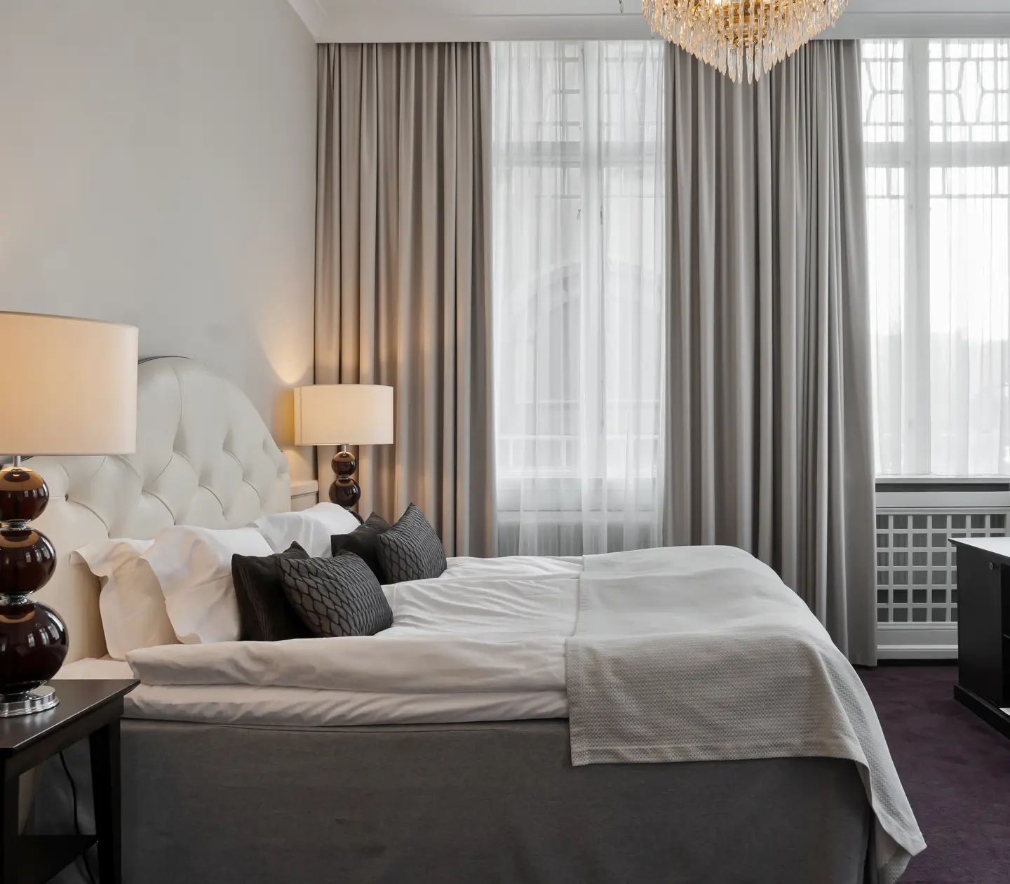 Suite with double bed, window and curtains