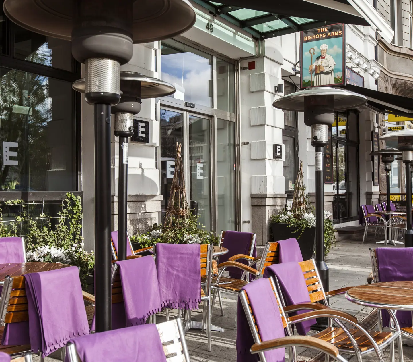 Outdoor seating with dining groups, heaters and purple blankets