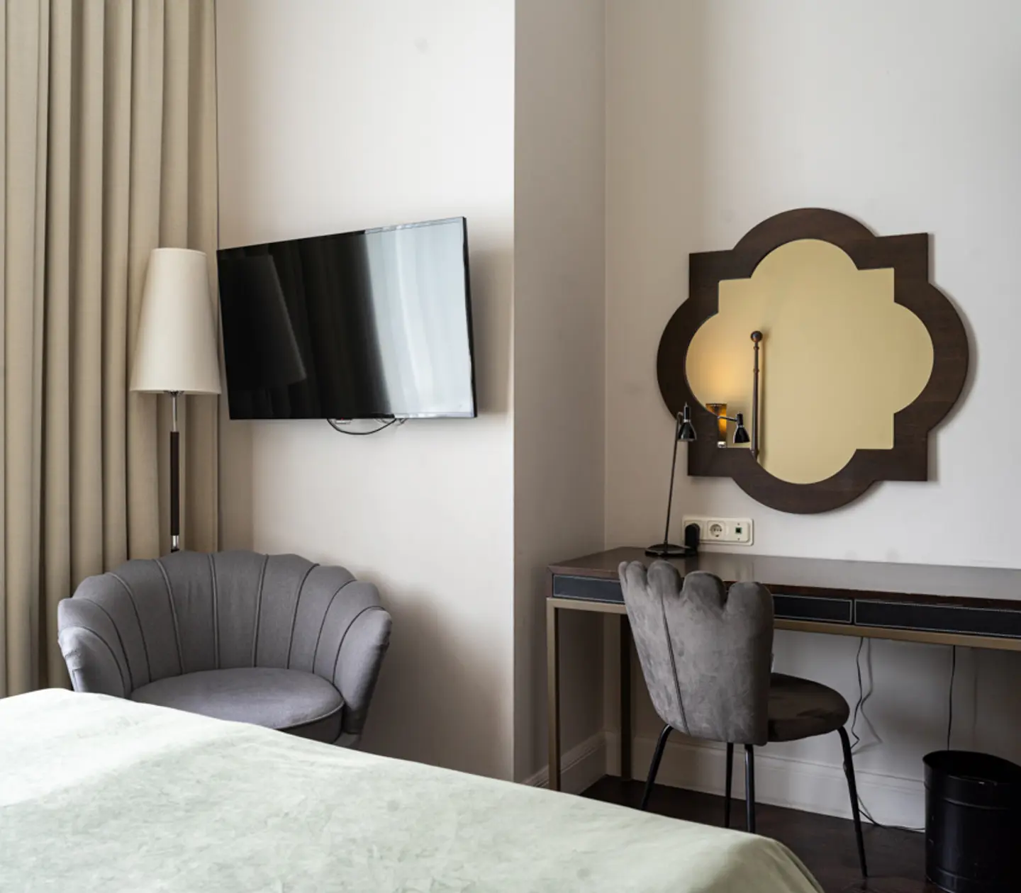 Bright hotel room with desk, mirror and bedside lamp