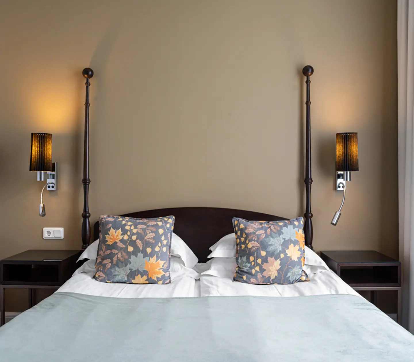 Bright hotel room with bed, bedside table and bedside lamps