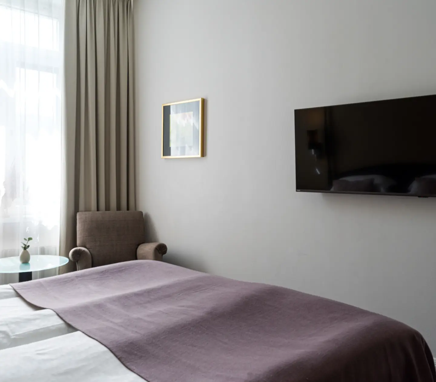 Bright hotel room with desk, mirror and bed