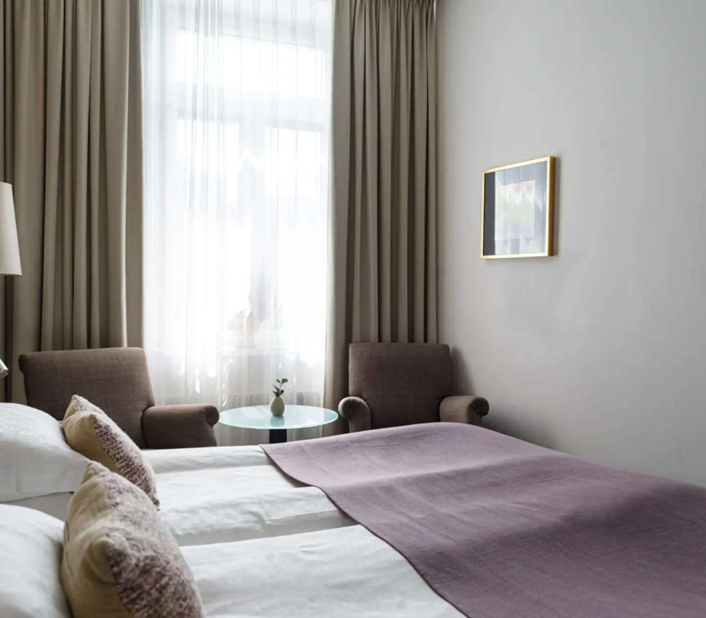 Bright hotel room with bed, desk and window