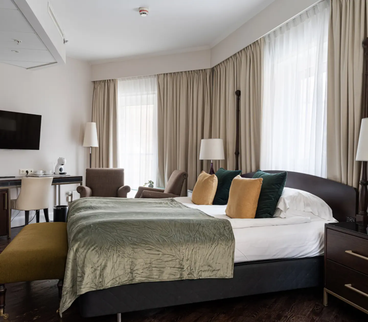 Cozy hotel room with bed, mirror and desk