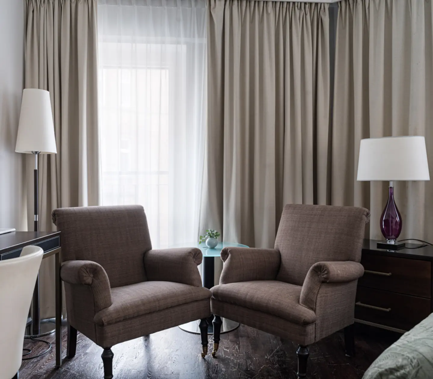 Cozy hotel room with bed, curtains and desk
