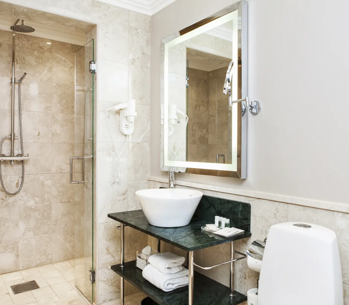 Beige bathroom with shower, sink and toilet