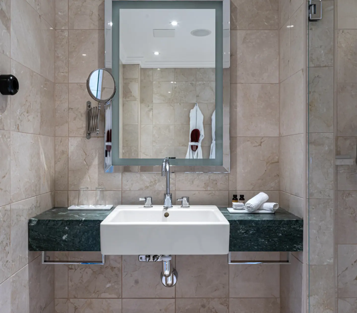 Beige bathroom with sink, mirror and towels