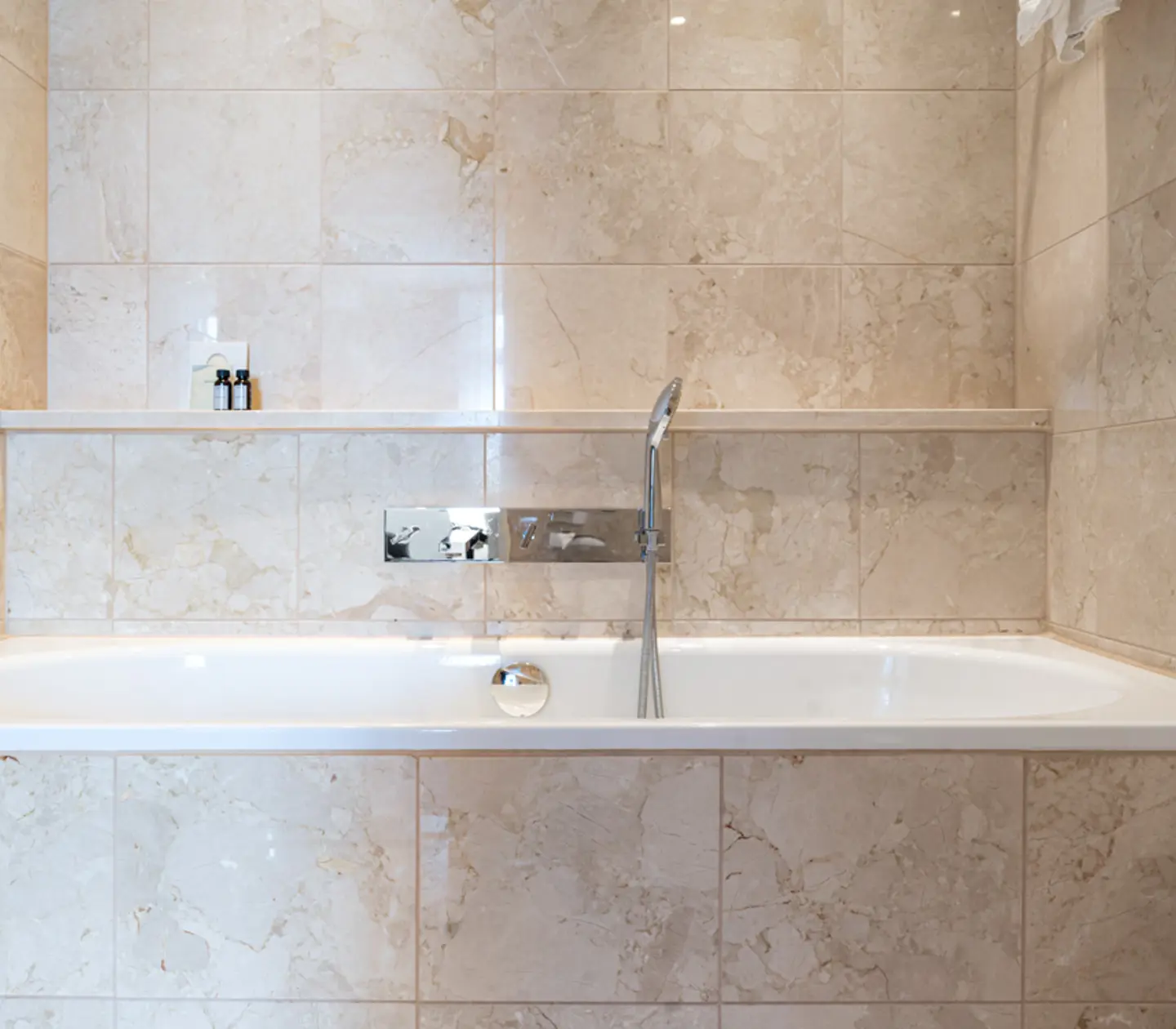 Beige bathroom with shower, bathtub and towels