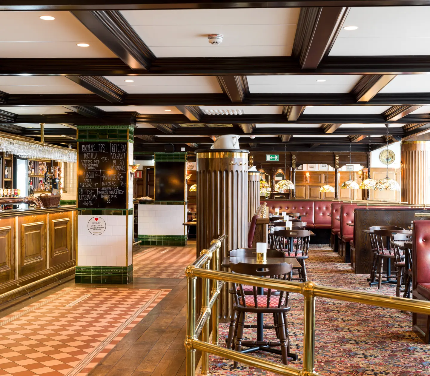 Pub environment with seating, bar and menus on blackboards