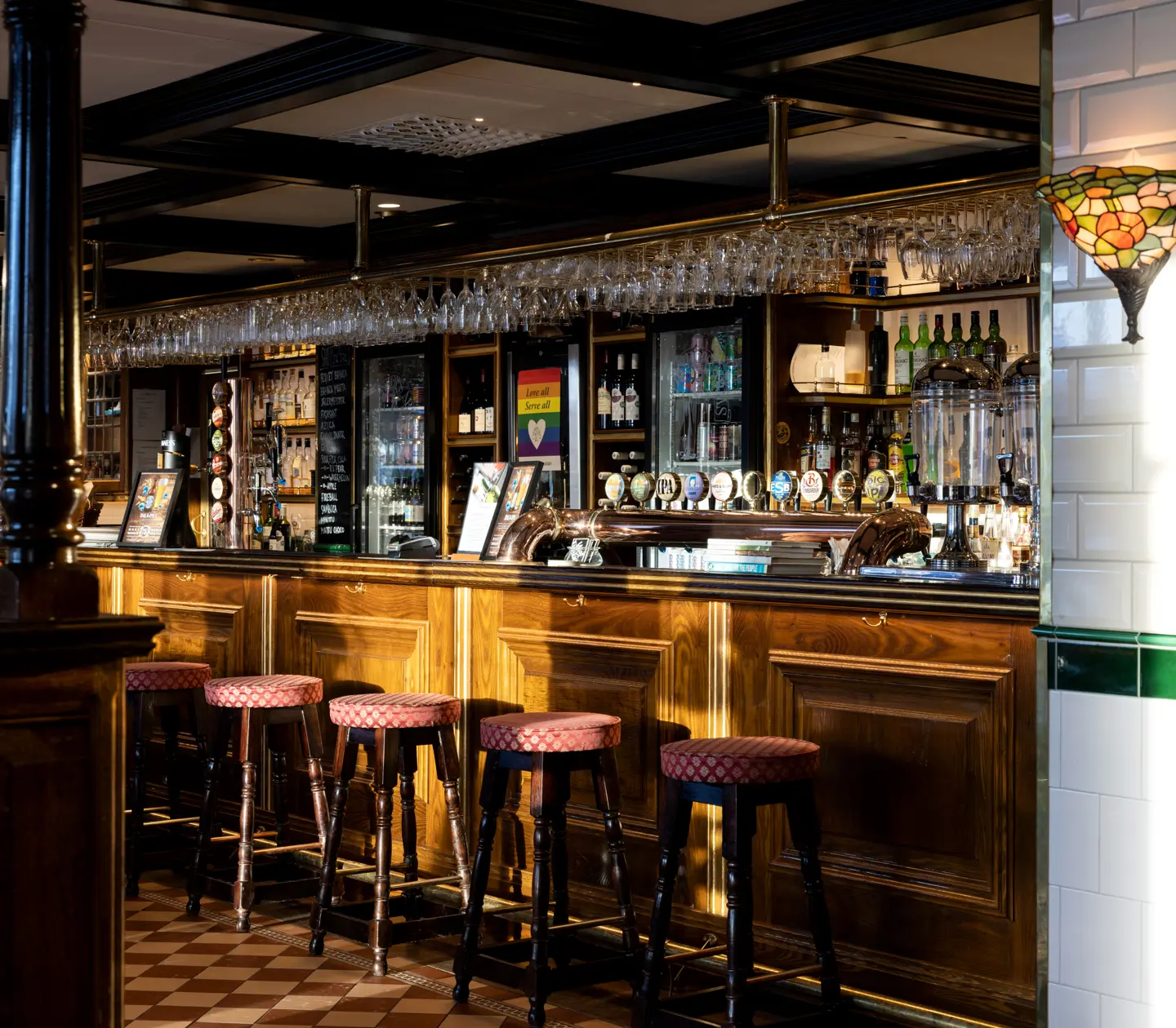 Pub environment with bar stools, bar and bottles