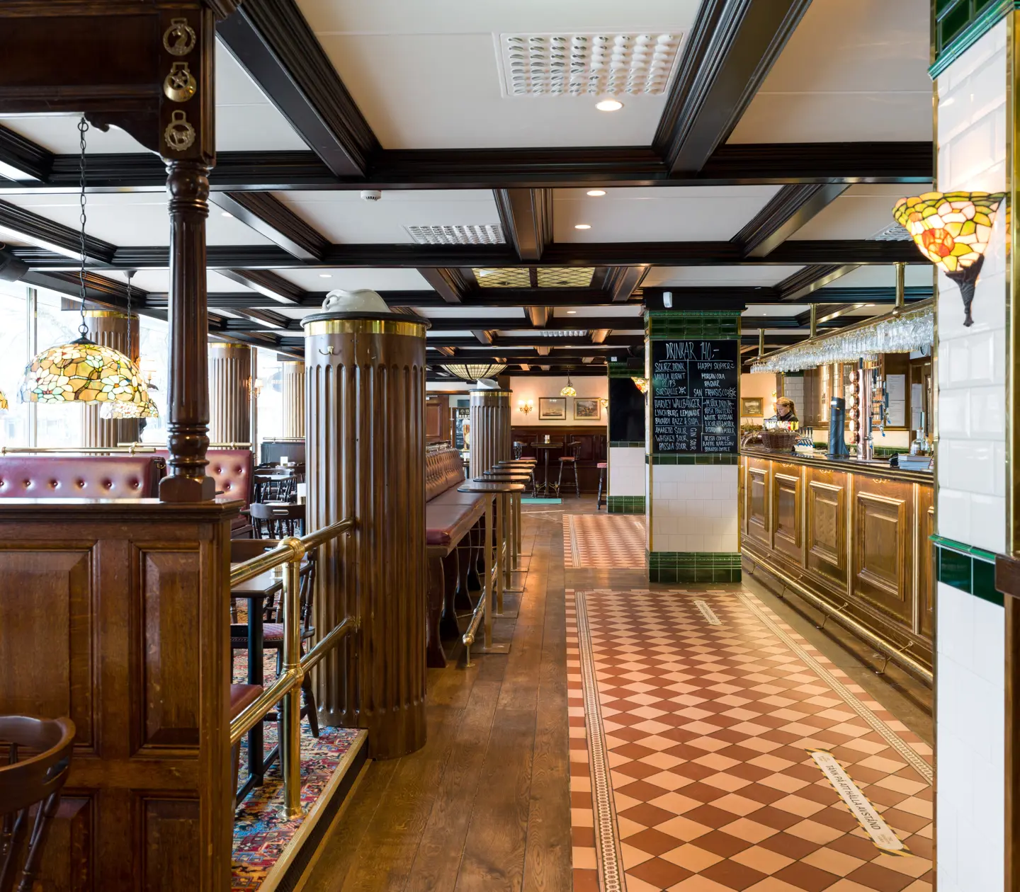 Pub environment with seating, bar and menus on blackboards