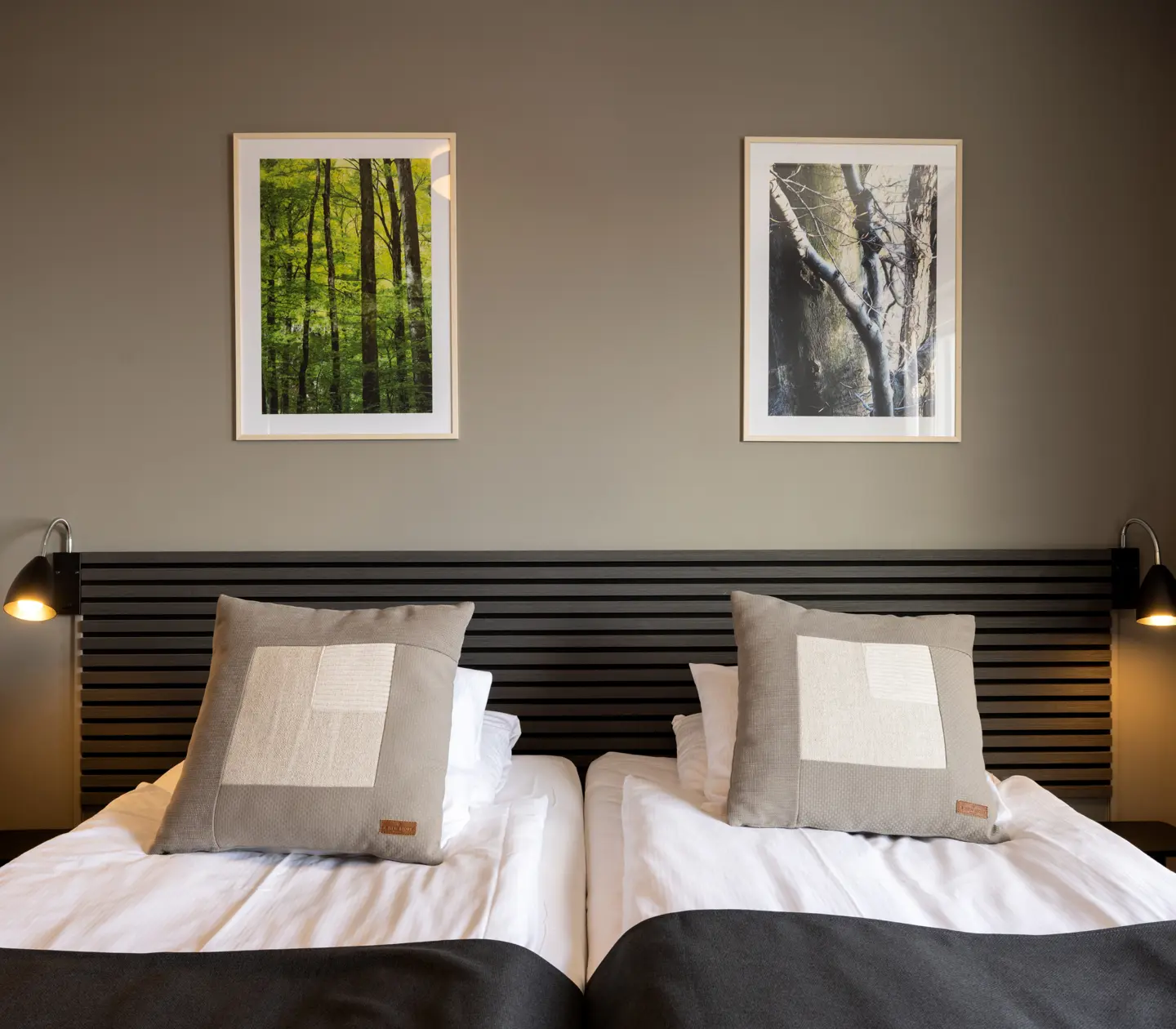 Hotel room with beds, black headboard and paintings