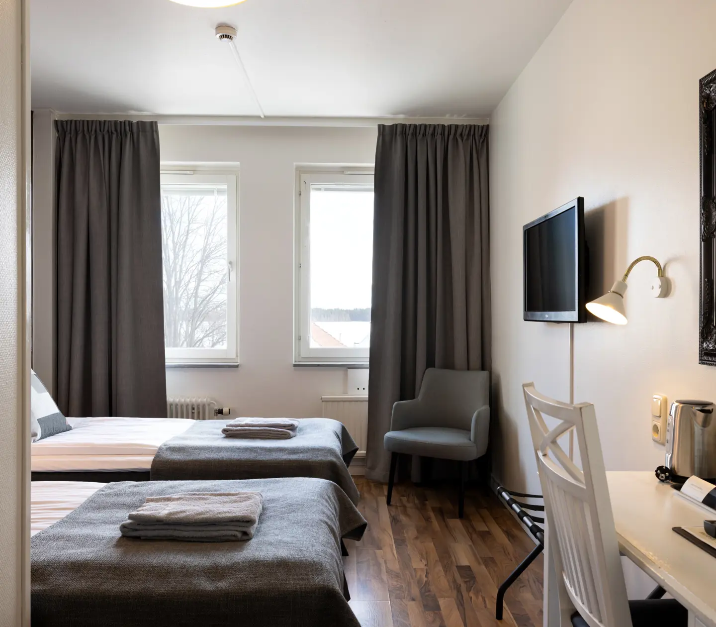 Hotel rooms with beds, desks and windows