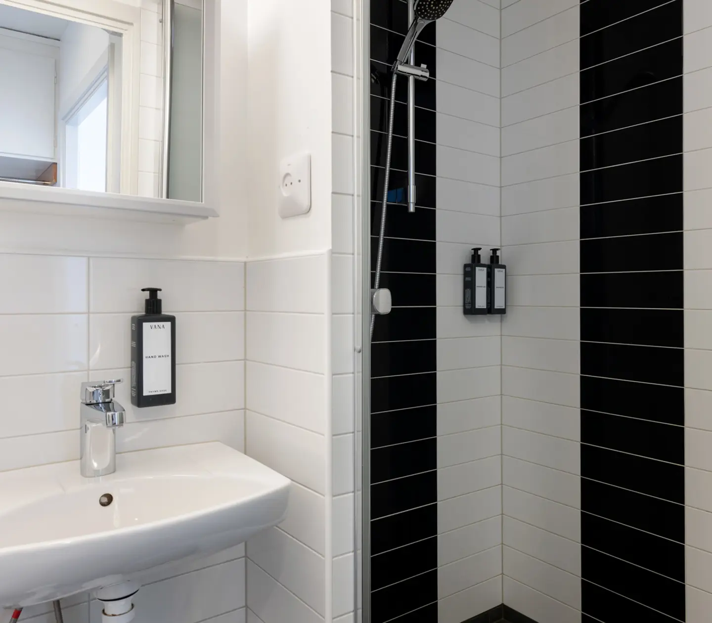 Black and white bathroom with shower, sink and mirror