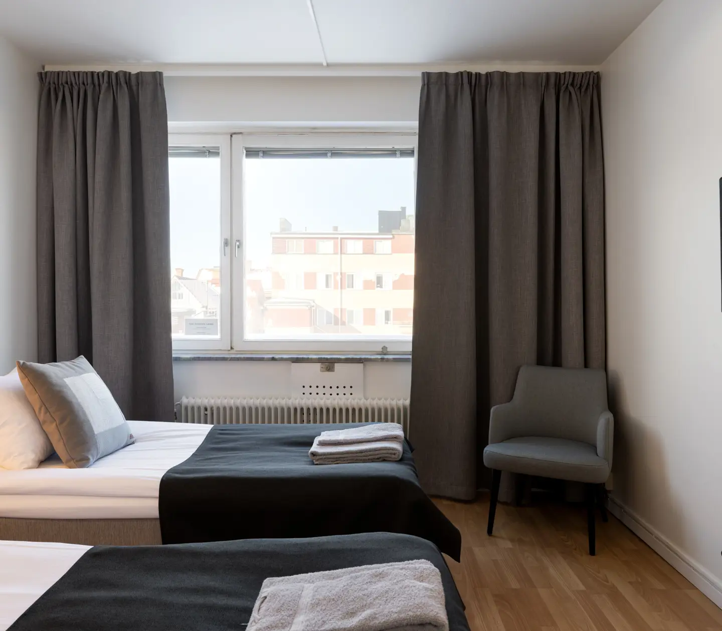 Hotel room with beds, wooden headboard and TV