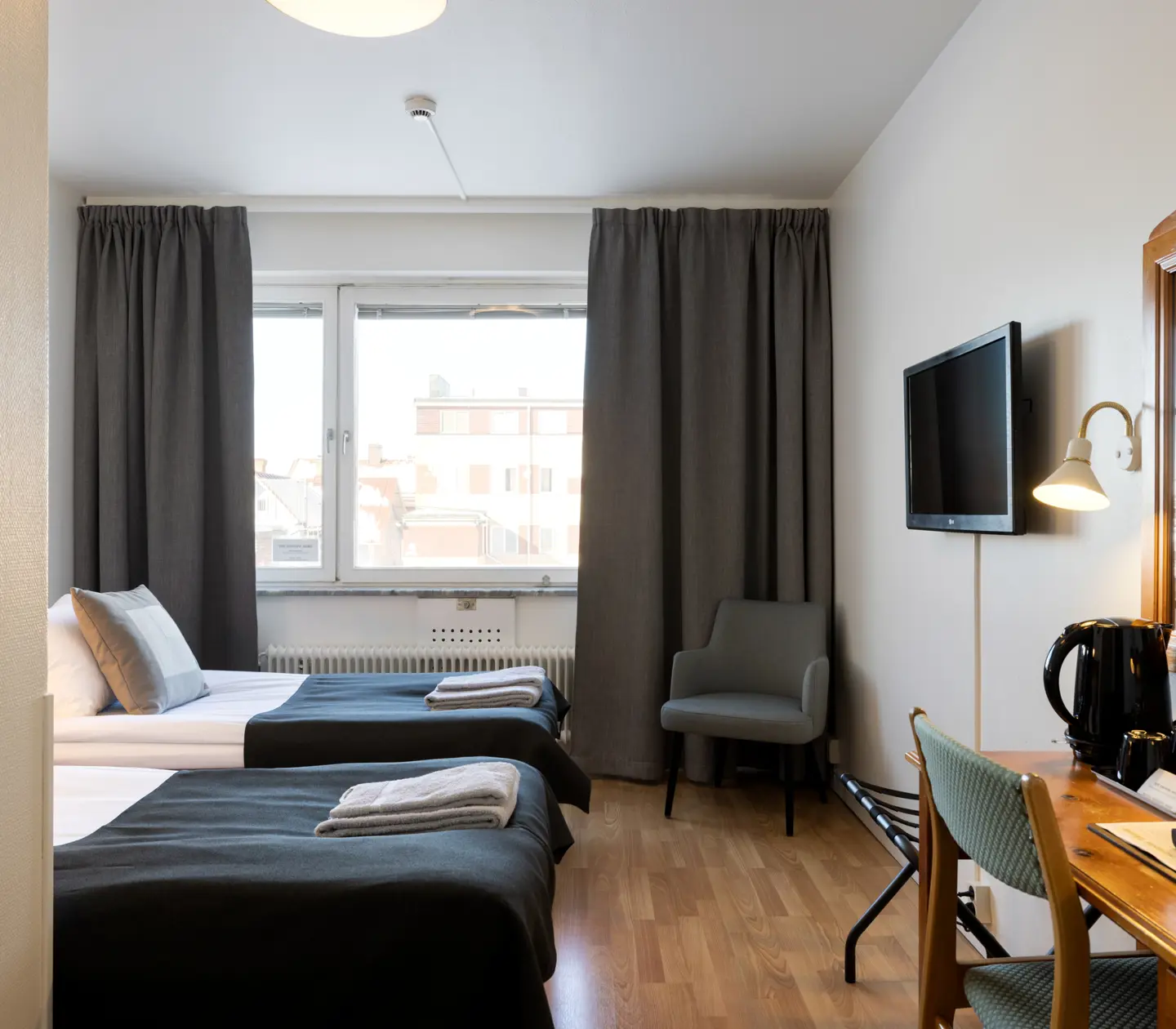 Hotel rooms with beds, desks and windows