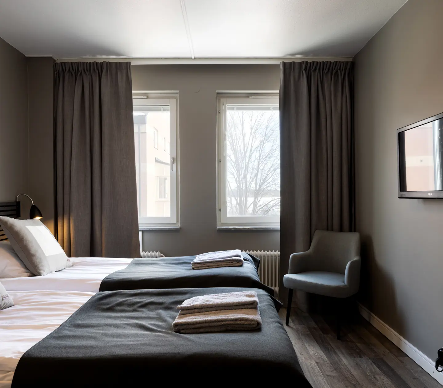 Hotel room with beds, black headboard and armchair