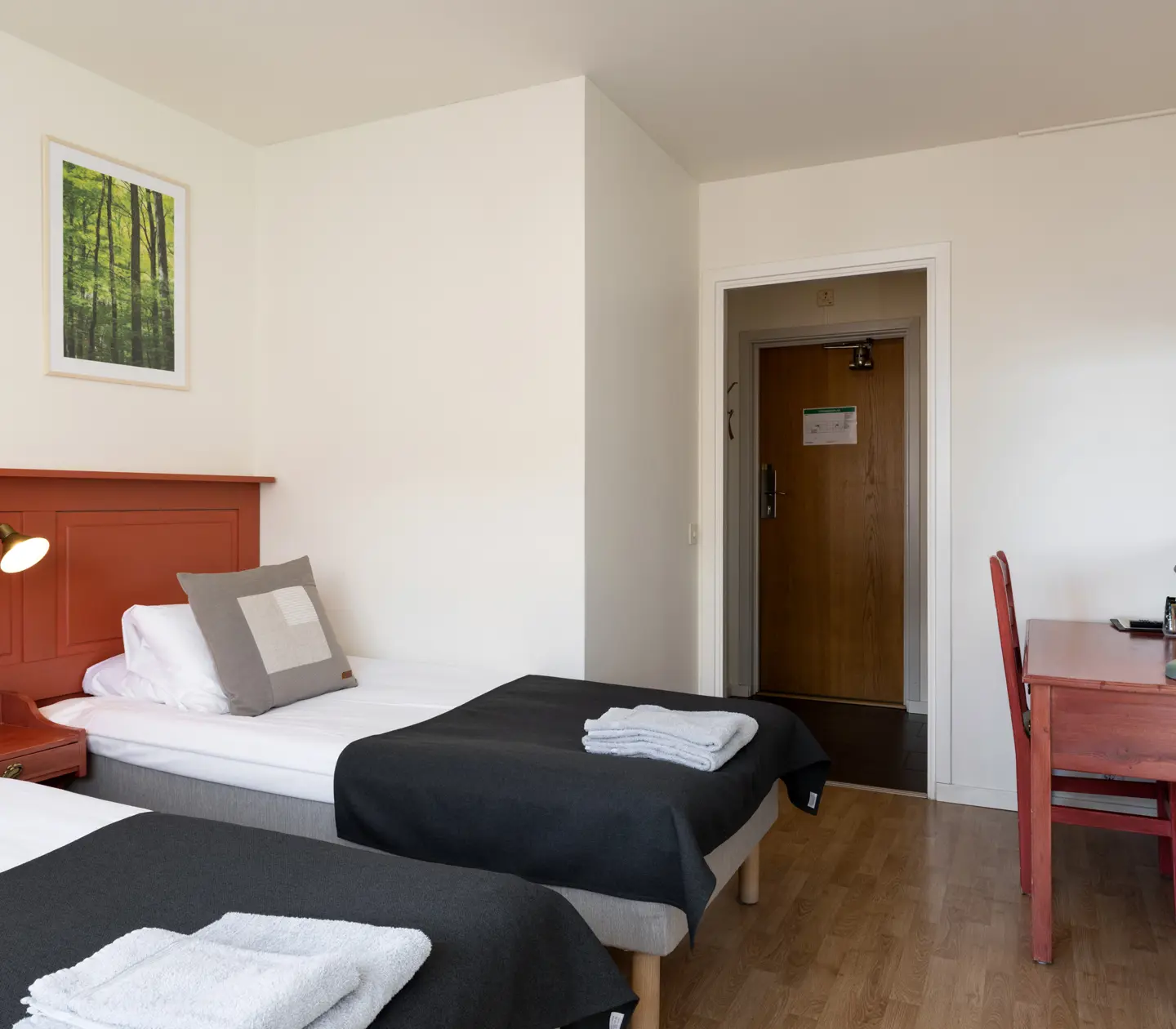 Hotel room with beds, burgundy headboard and desk