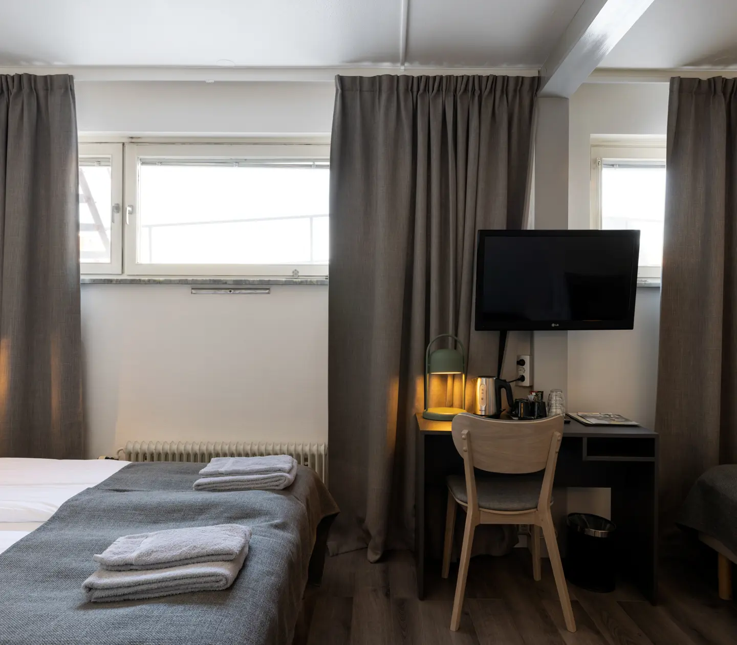 Hotel room with three beds, desk and TV