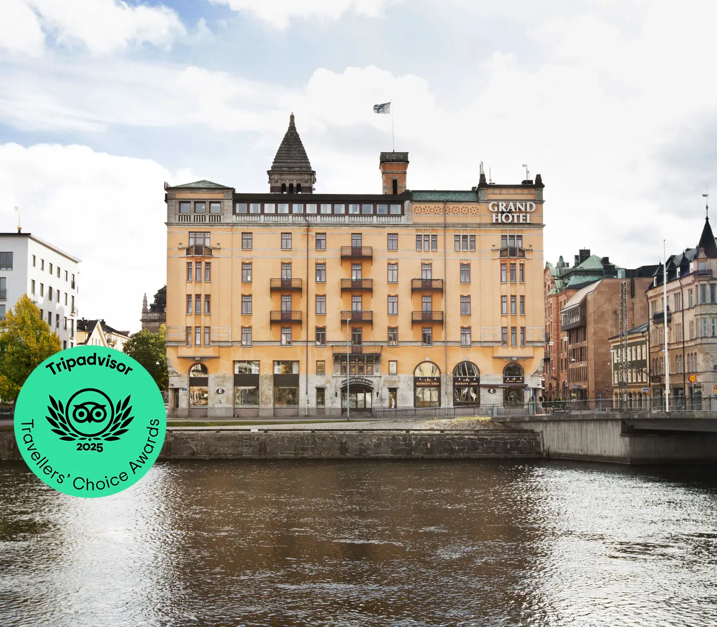 Orange fasaden av Elite Grand Hotel i Norrköping med Motala Ström framför