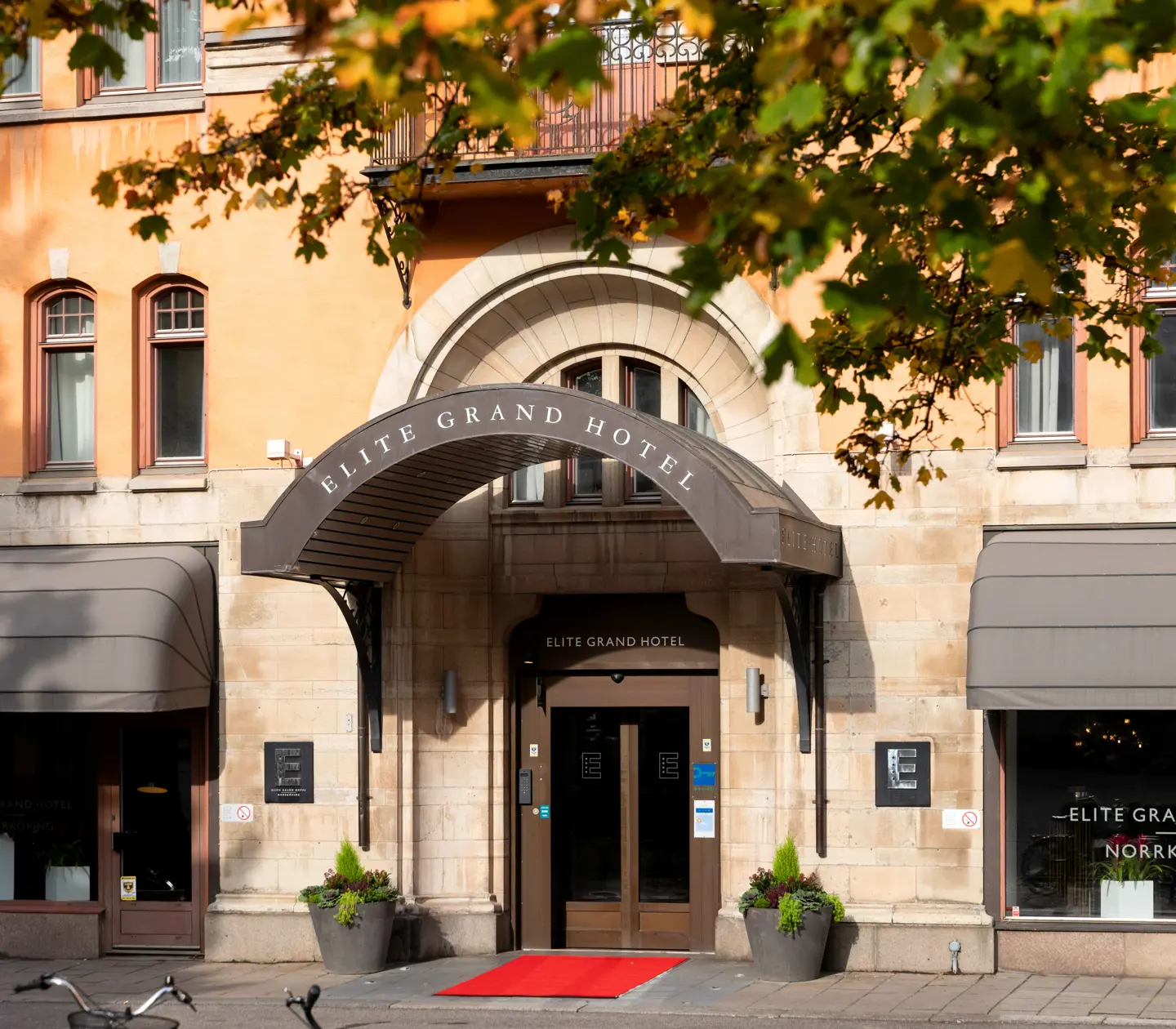 The entrance to the Elite Grand Hotel with a grand ceiling, red carpet and large doors