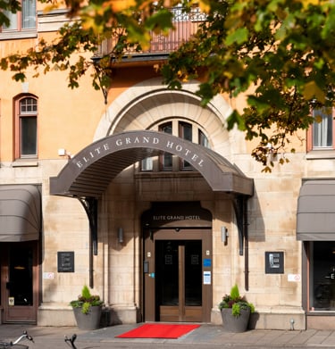 Entrén till Elite Grand Hotel med pampigt tak, röd matta och stora dörrar