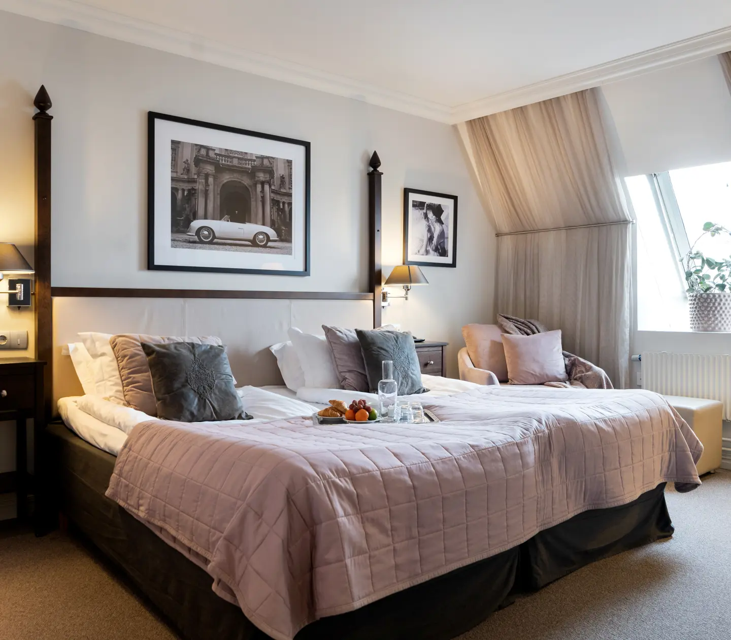Hotel room with large bed, armchair and sloping ceiling