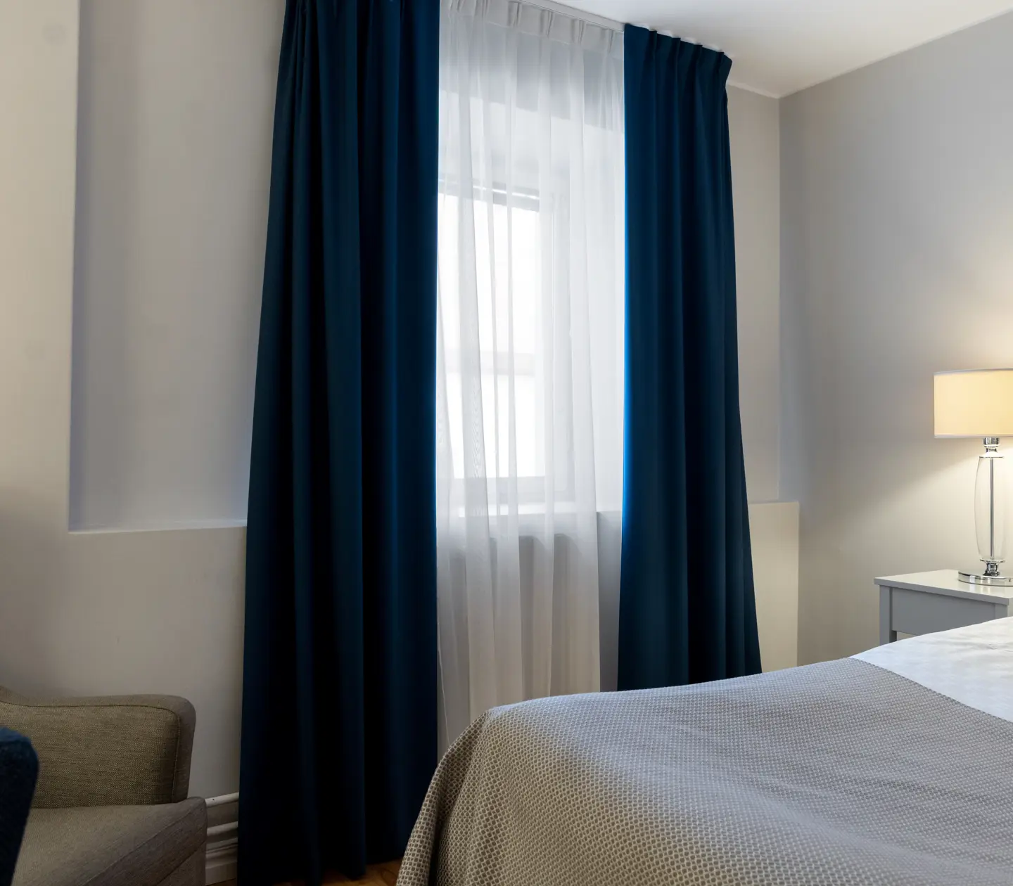 Bright hotel room with bed, window and curtains