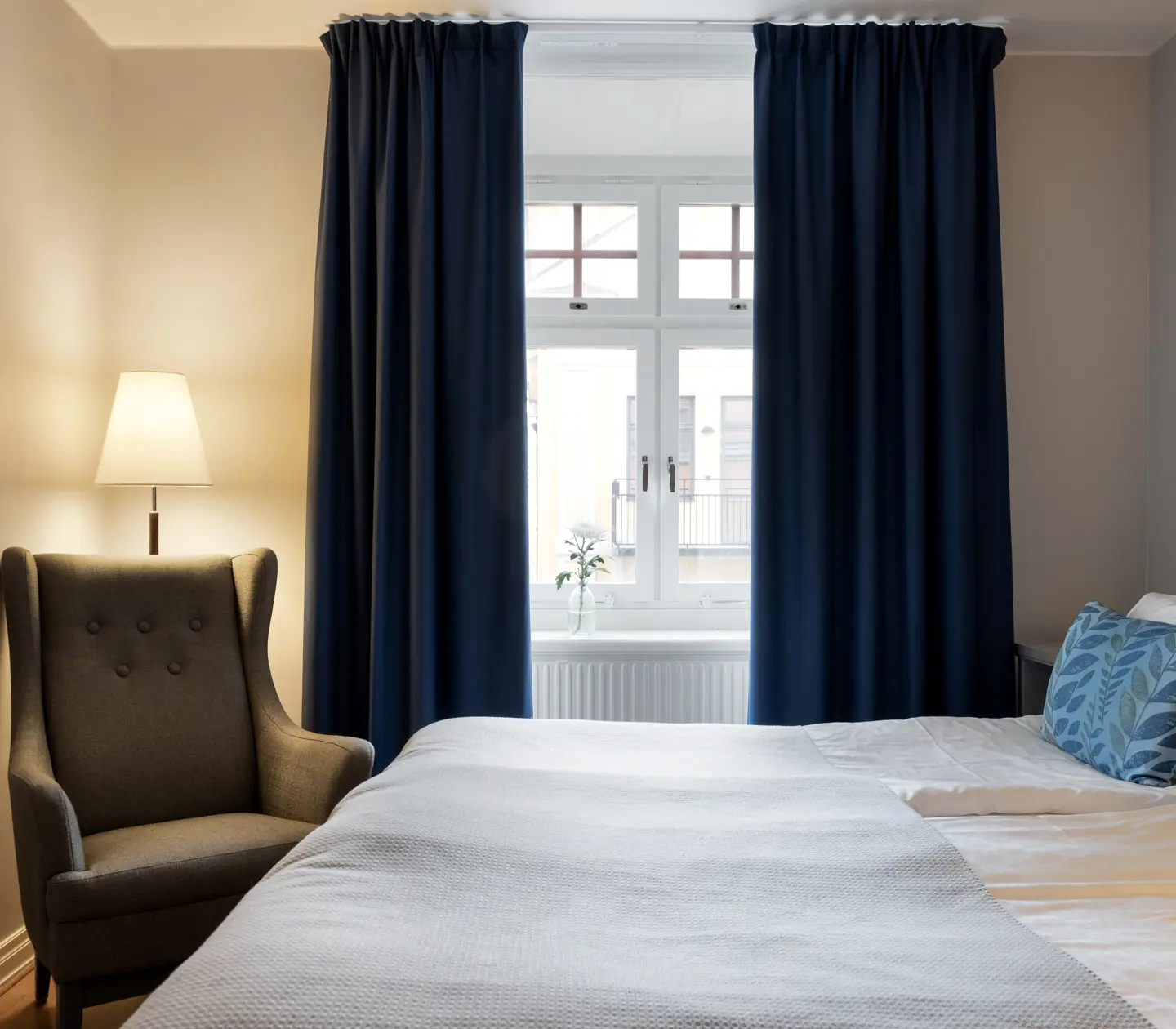 Bright hotel room with bed, armchair and window