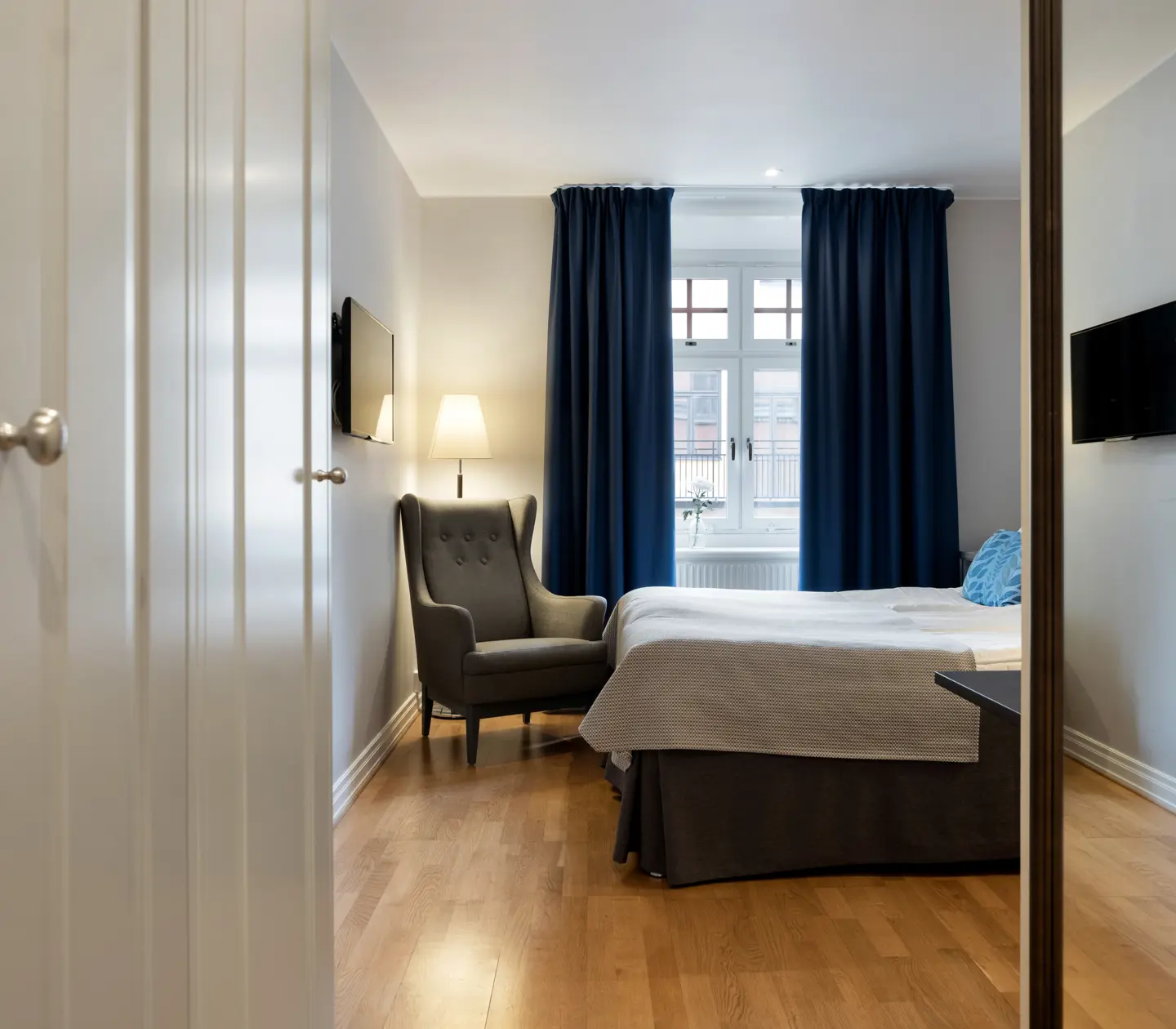 Bright hotel room with bed, armchair and window