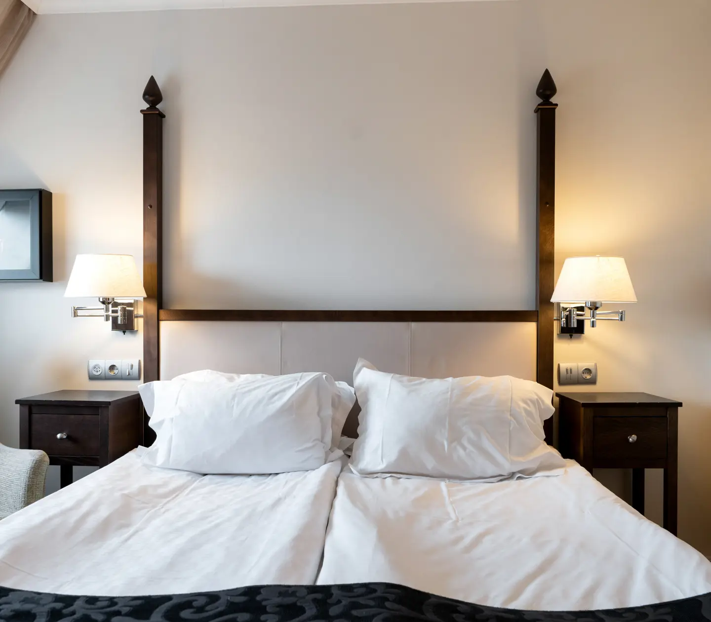Bright hotel room with bed, painting and armchair