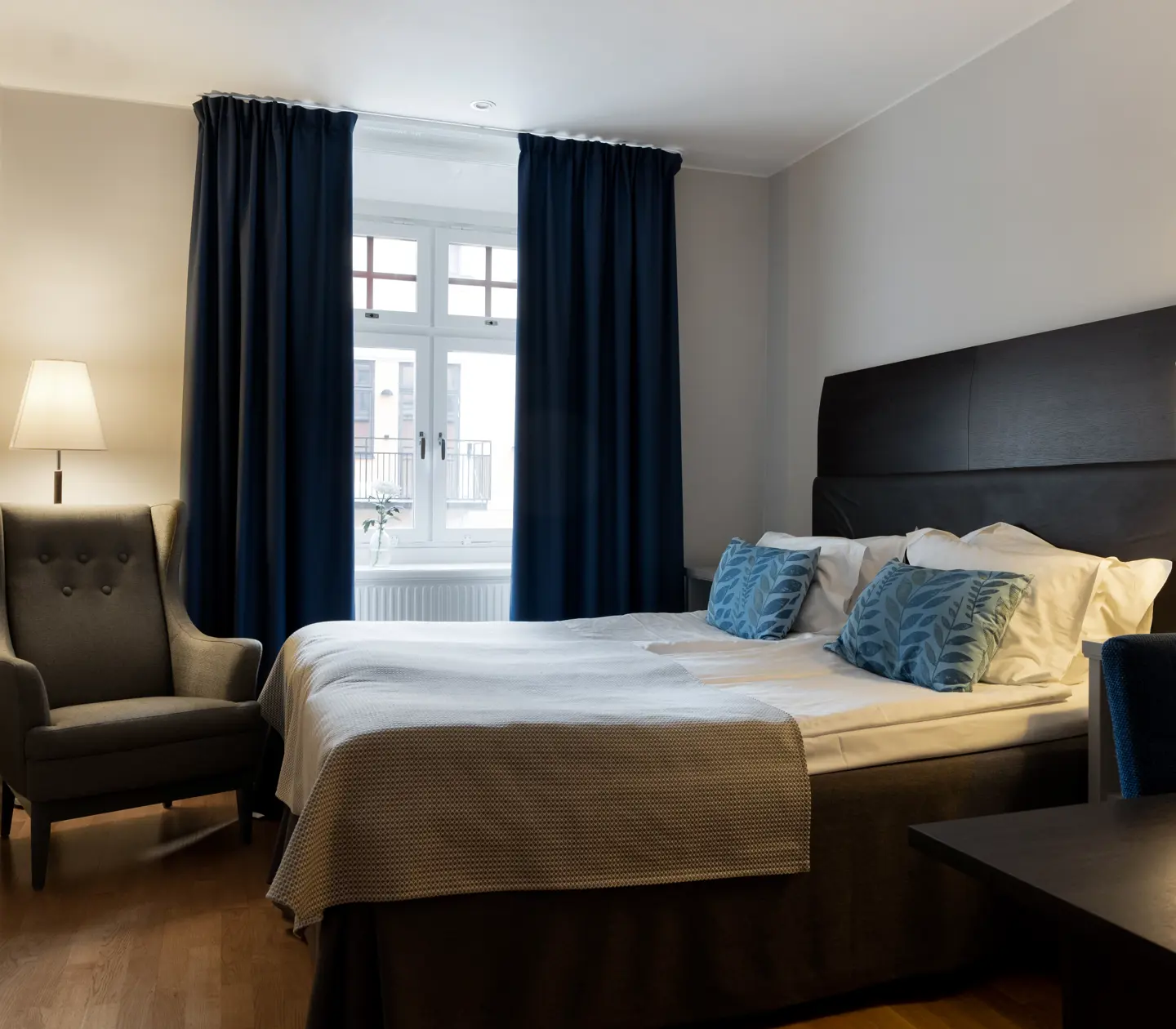 Bright hotel room with bed, armchair and window