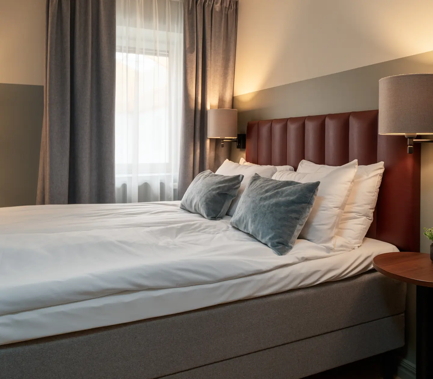 Comfortable hotel room with double bed, bedside lamps and window