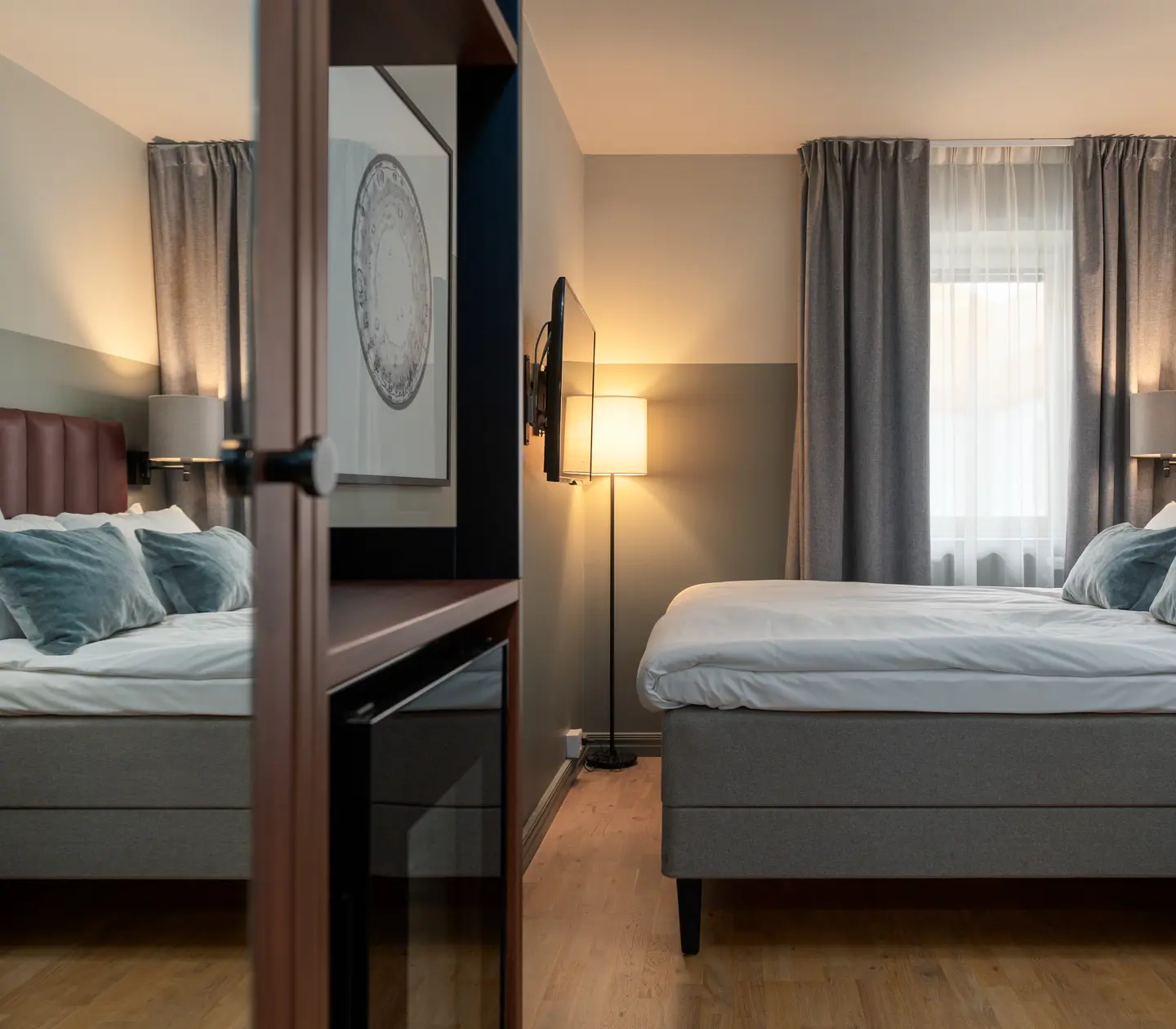 Comfortable hotel room with double bed, mirror and window