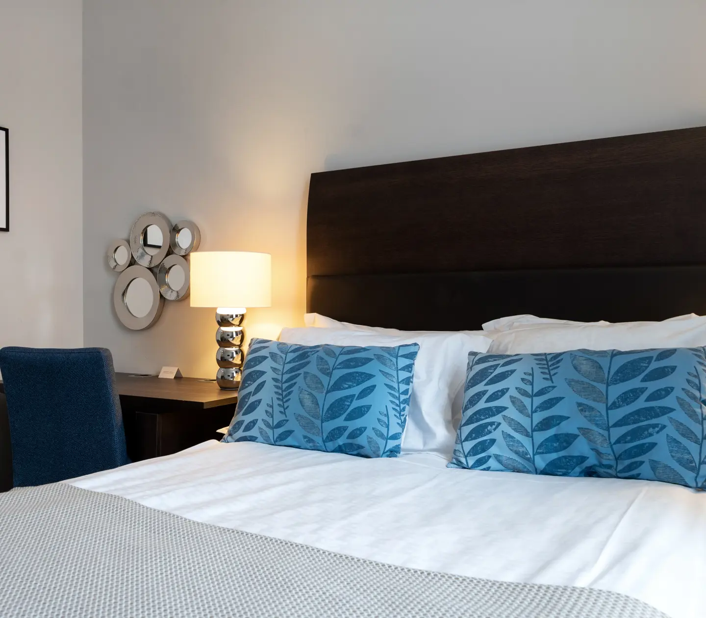 Bright hotel room with bed, desk and blackboard