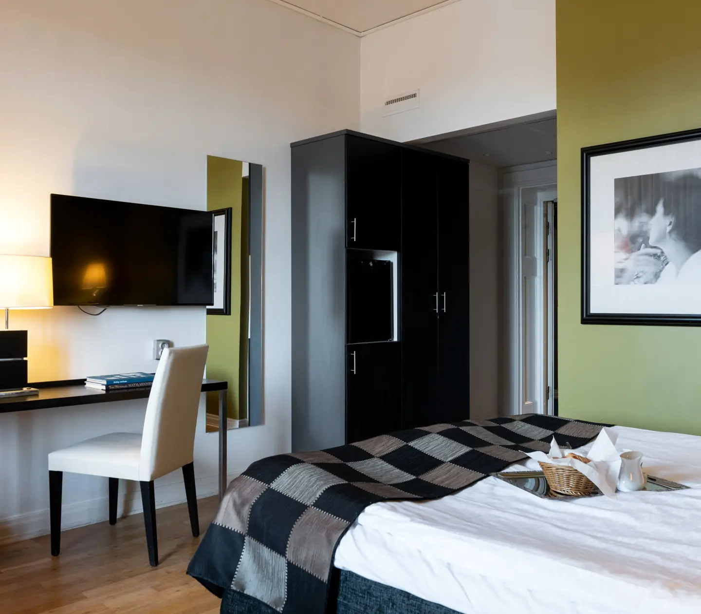 Hotel room with green wall, bed and desk
