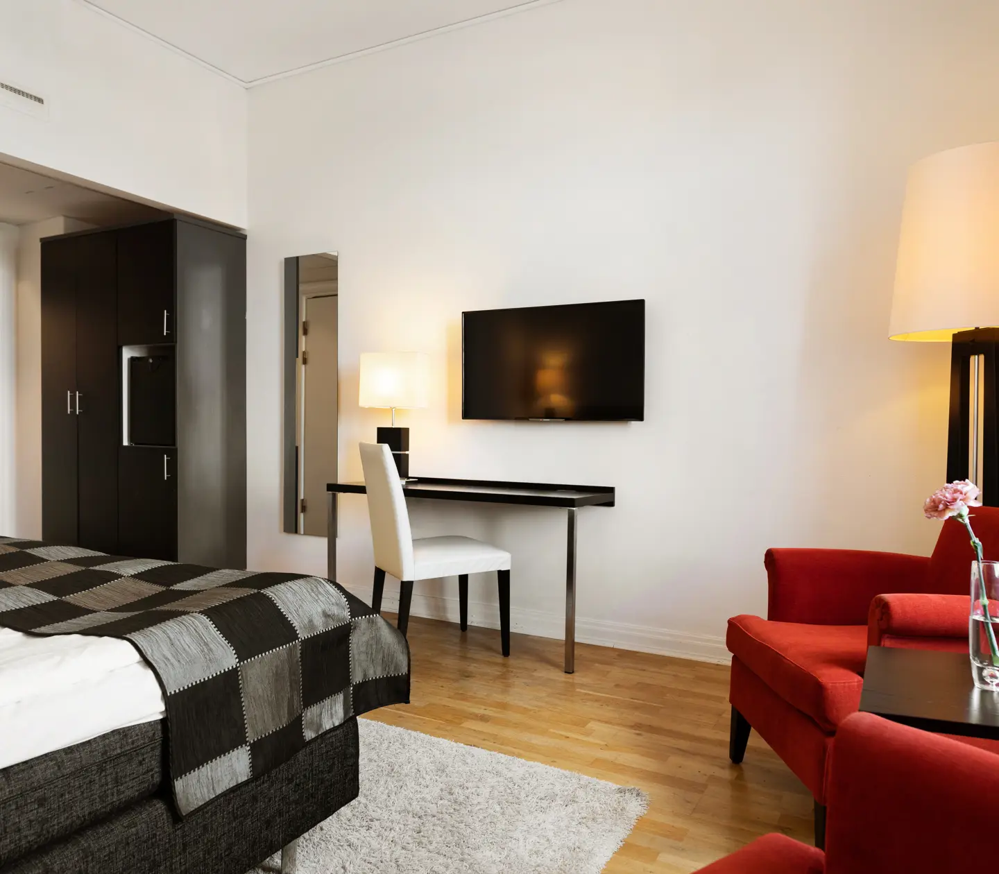Hotel room with red armchairs, desk and wardrobe