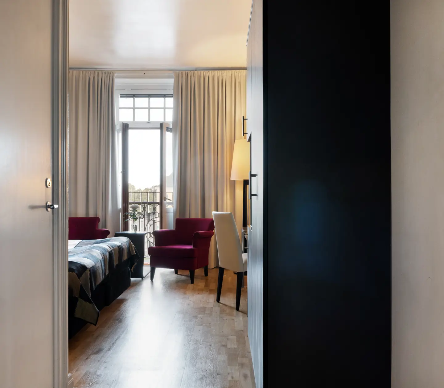 Hotel room armchairs, door to balcony and wardrobe