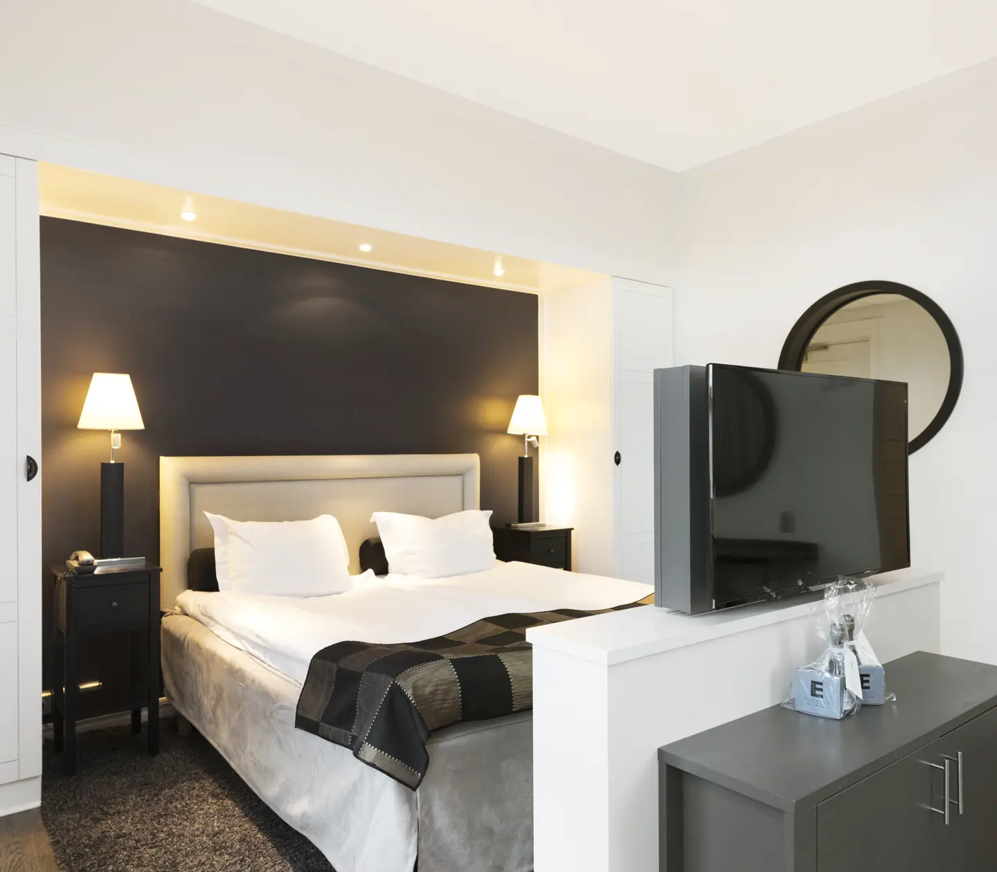 Bright hotel room with bed, TV and wardrobe