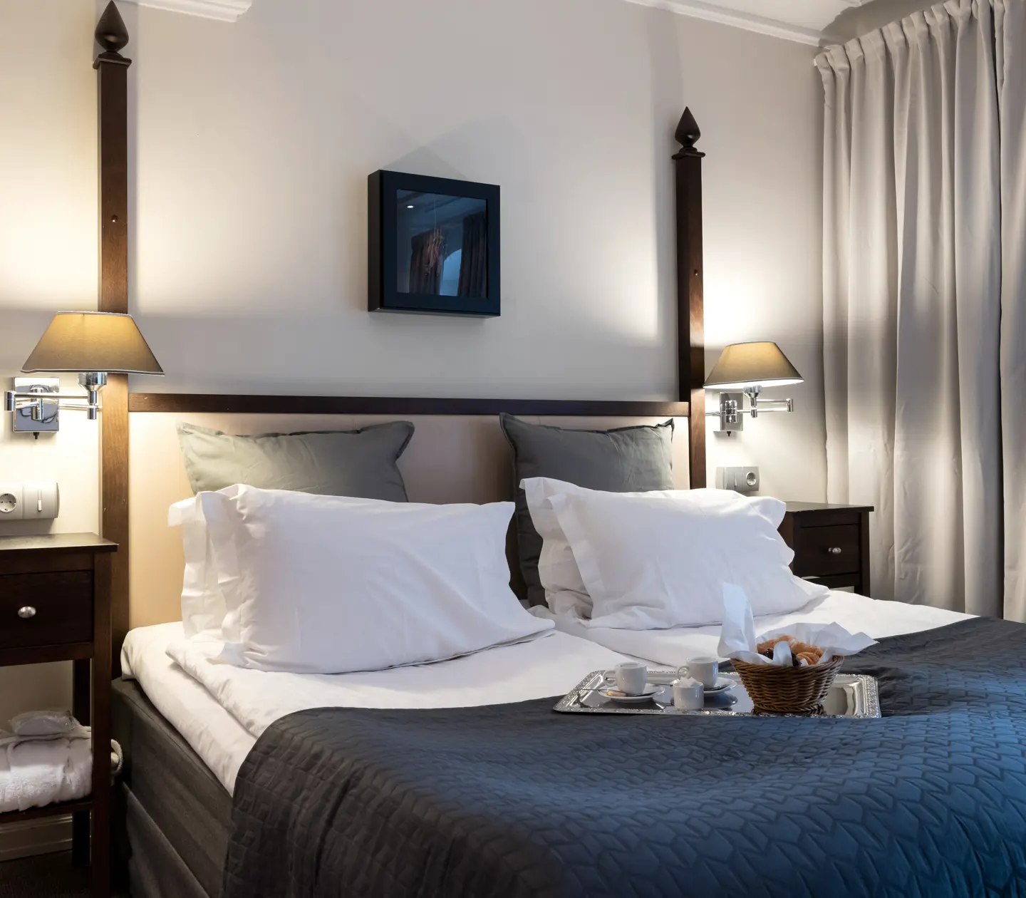 Bright hotel room with curtains, bed and bedside table