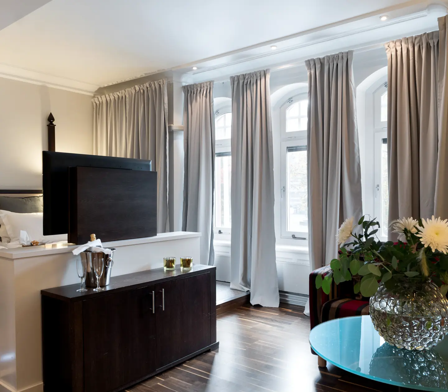 Hotel room with bed, bouquet and many windows