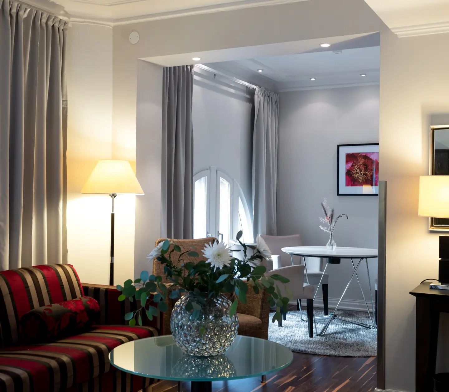 Hotel room with dining table, bouquet and sofa