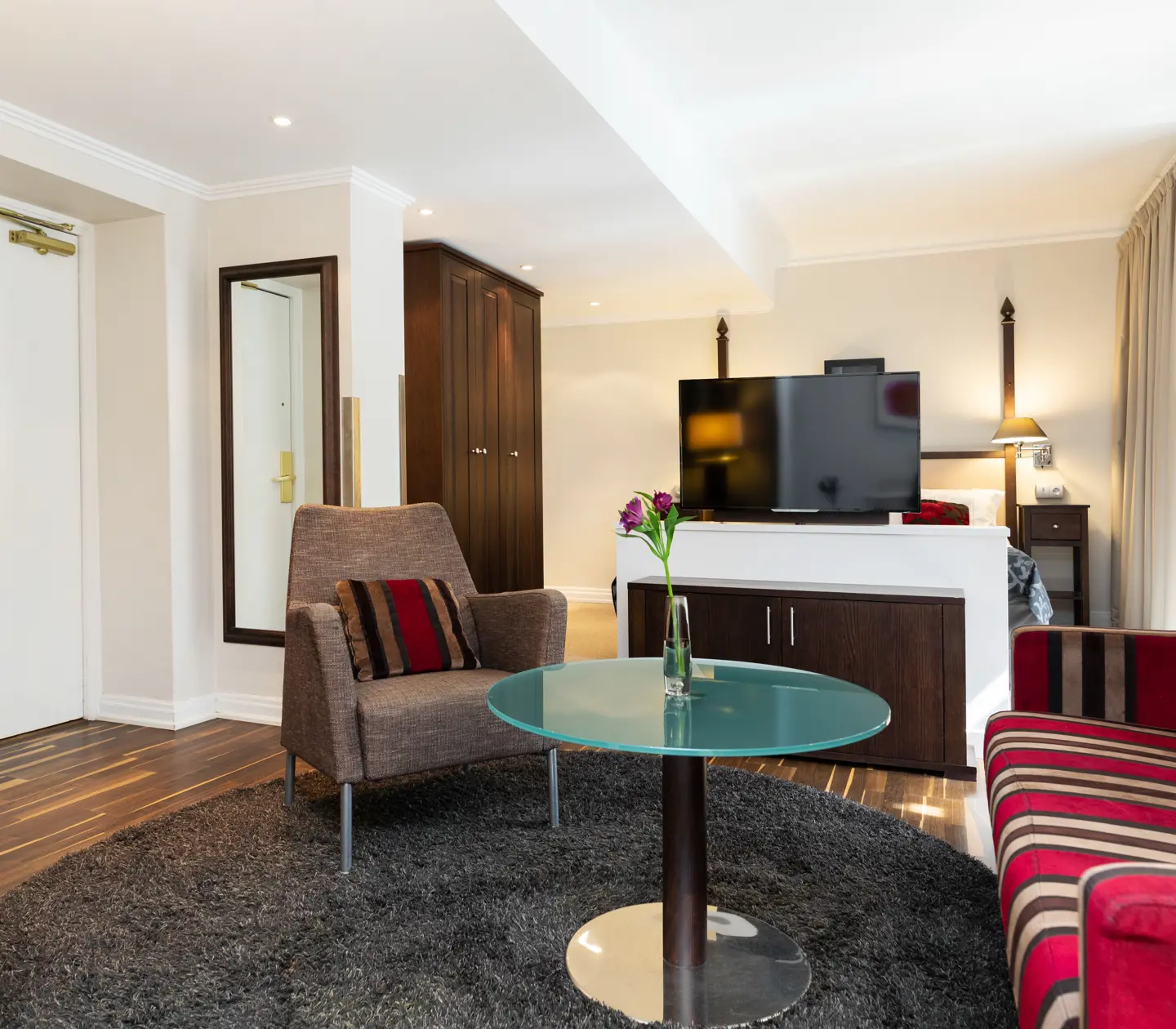 Hotel room with sofa group, TV and wardrobe