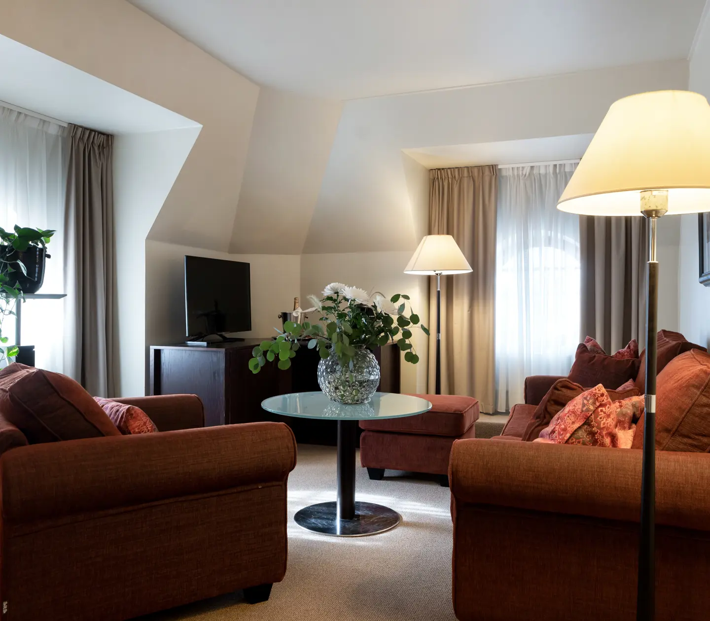 Cozy suite with sofa group, plants and windows
