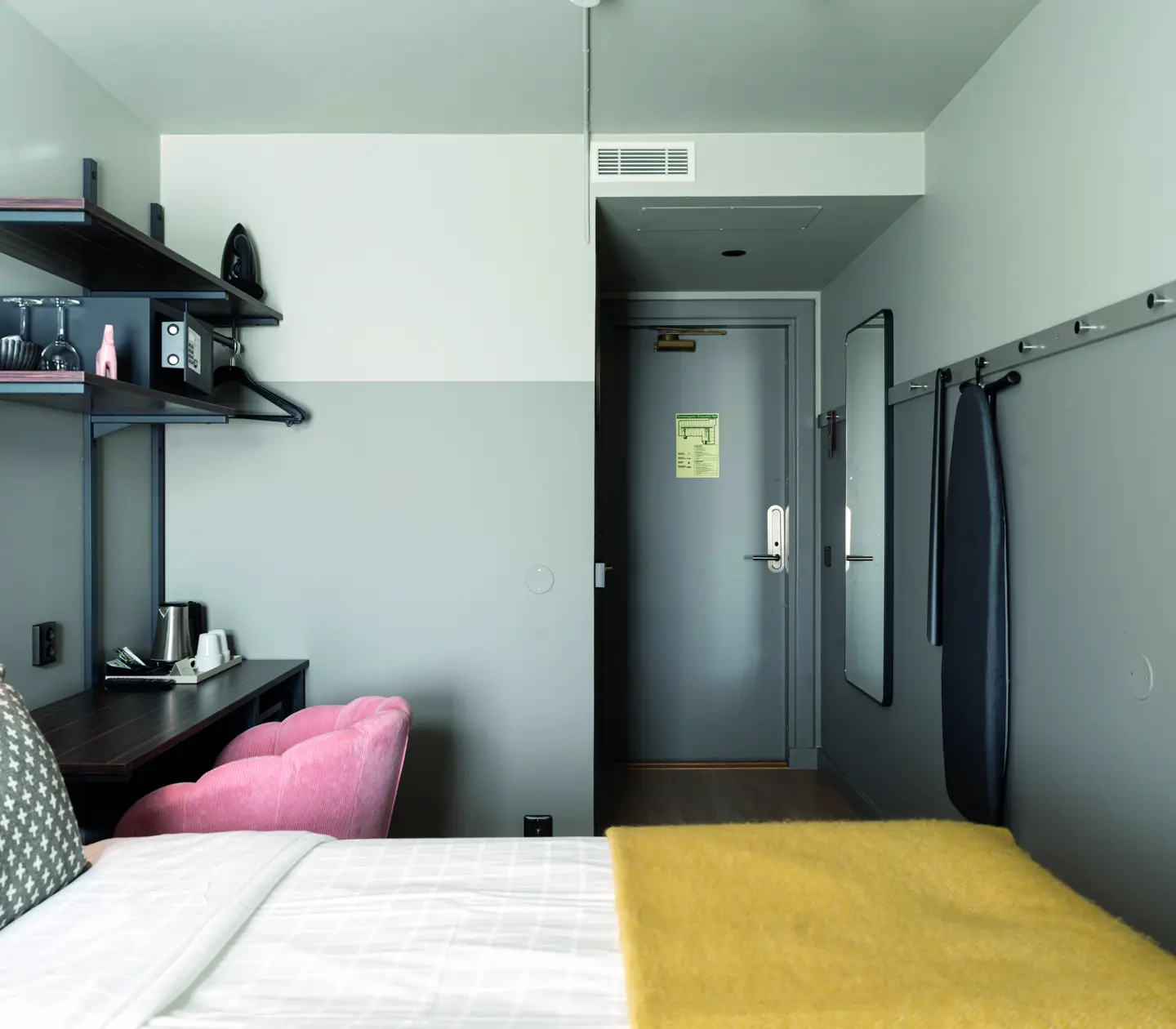 Small double room with a double bed, a desk and a pink chair