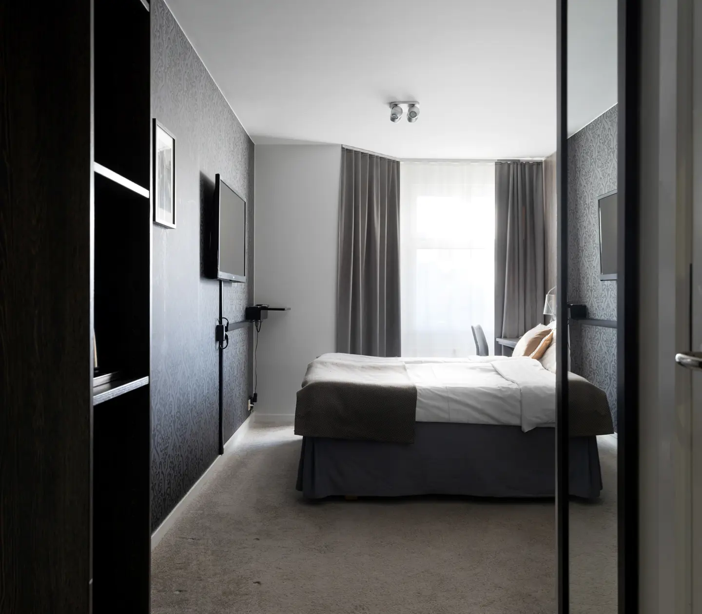 Hotel room with double bed, window and TV