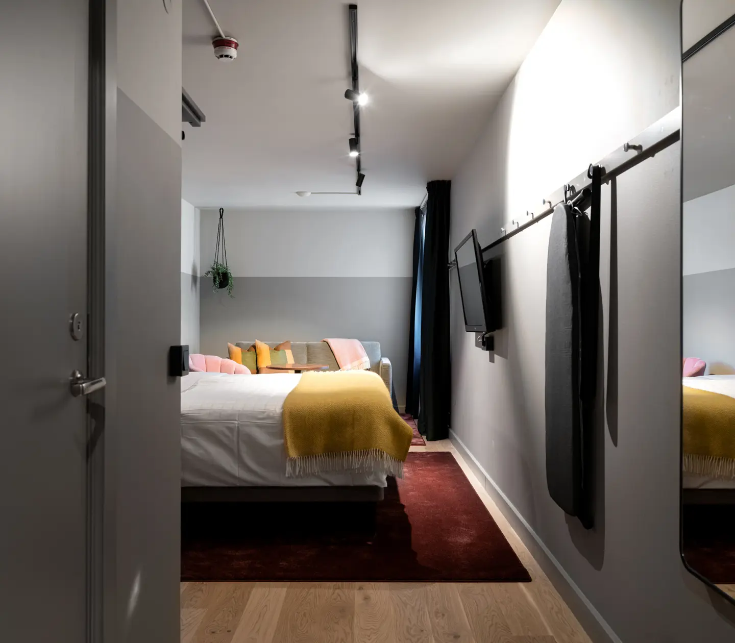 Hotel room with mirror, double bed and TV
