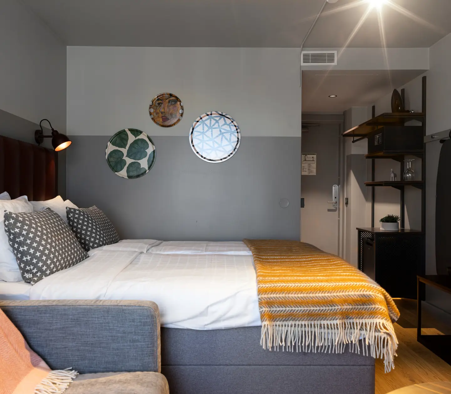 Hotel room with double bed, paintings and wardrobe