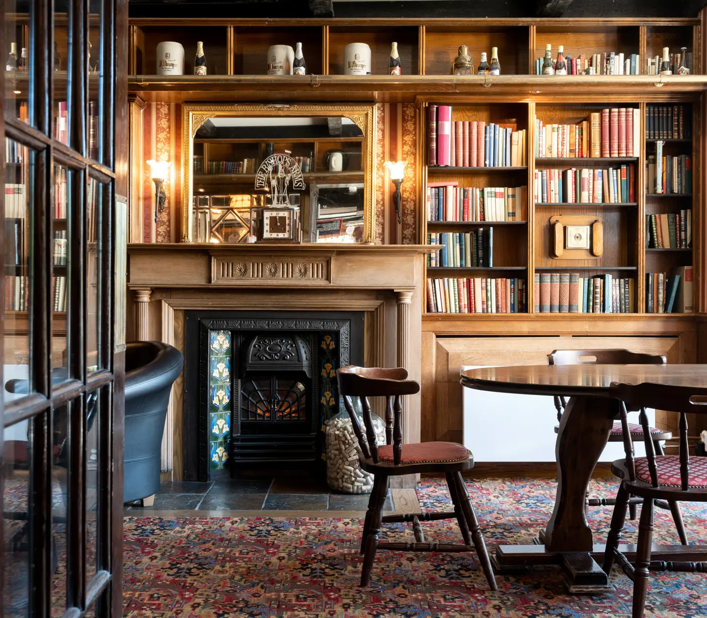 Pub atmosphere at The Bishops Arms with chairs, log fire and books