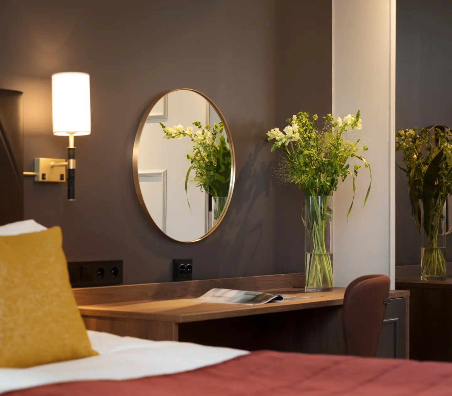 Hotel room with double bed, desk, bouquet and mirror